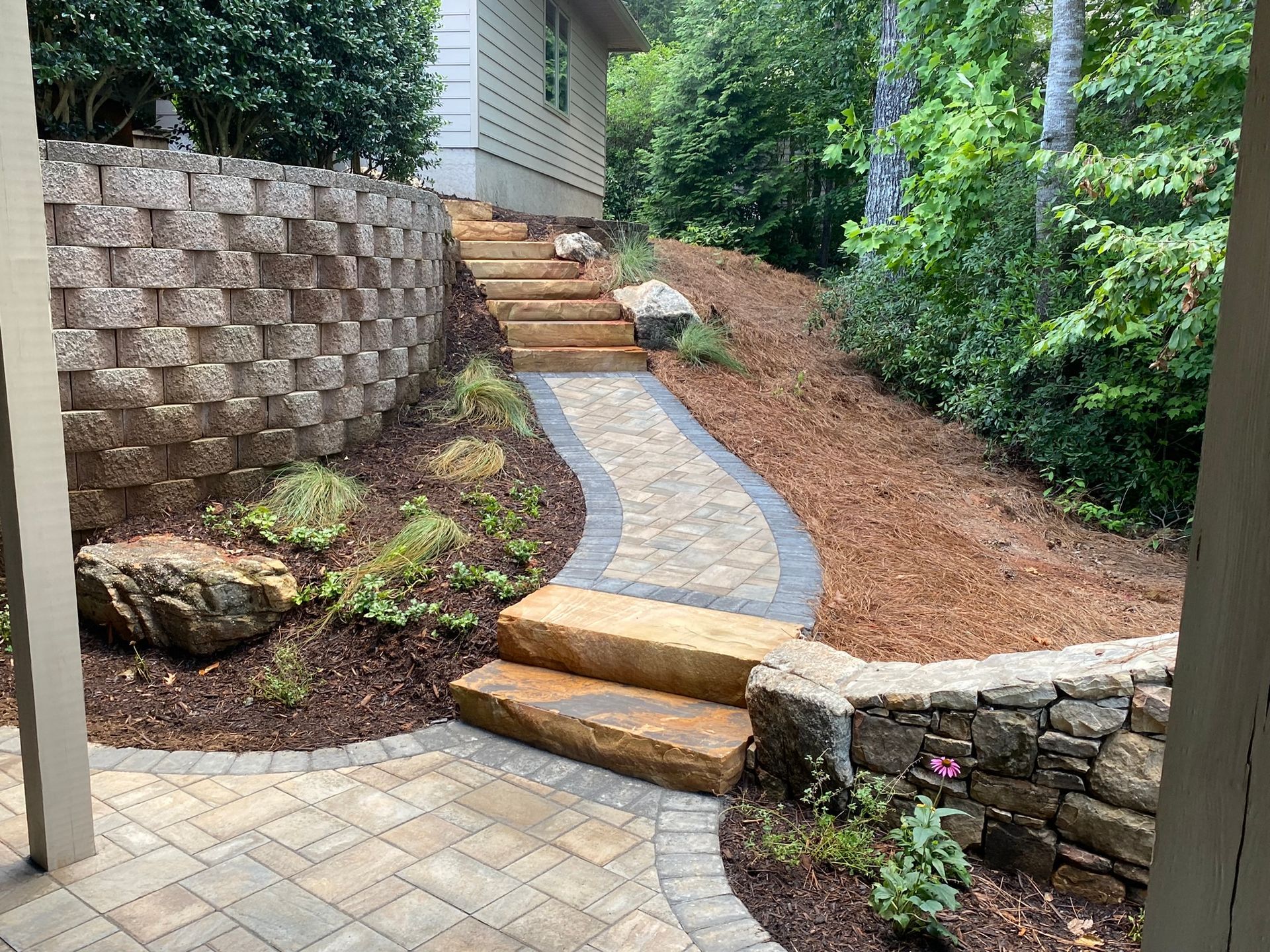 A stone walkway with stairs leading up to a house.
