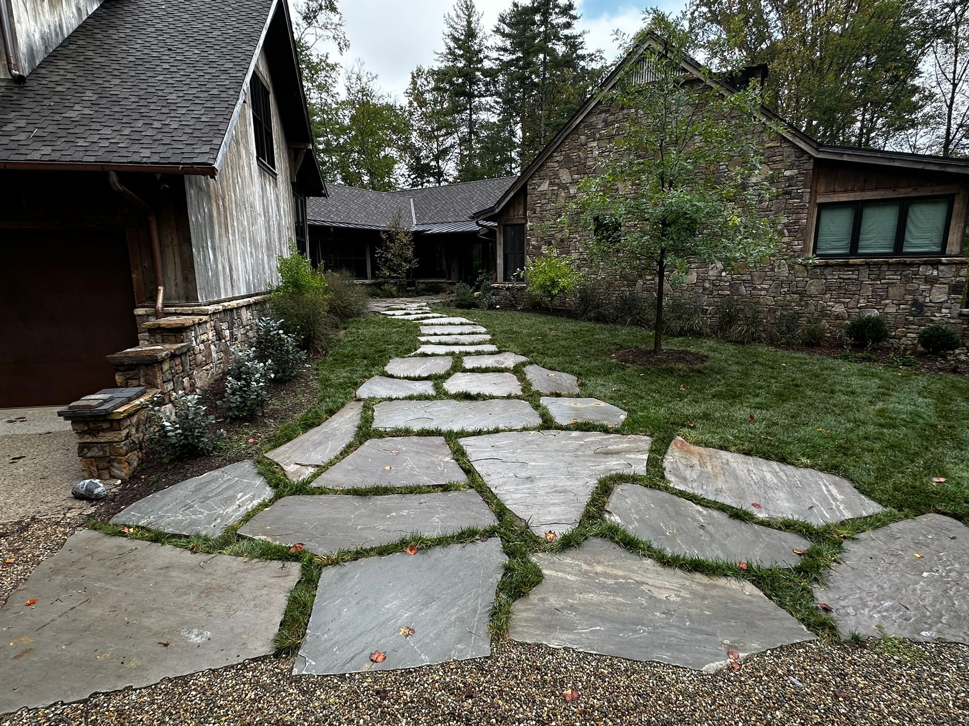 There is a stone walkway leading to a house.