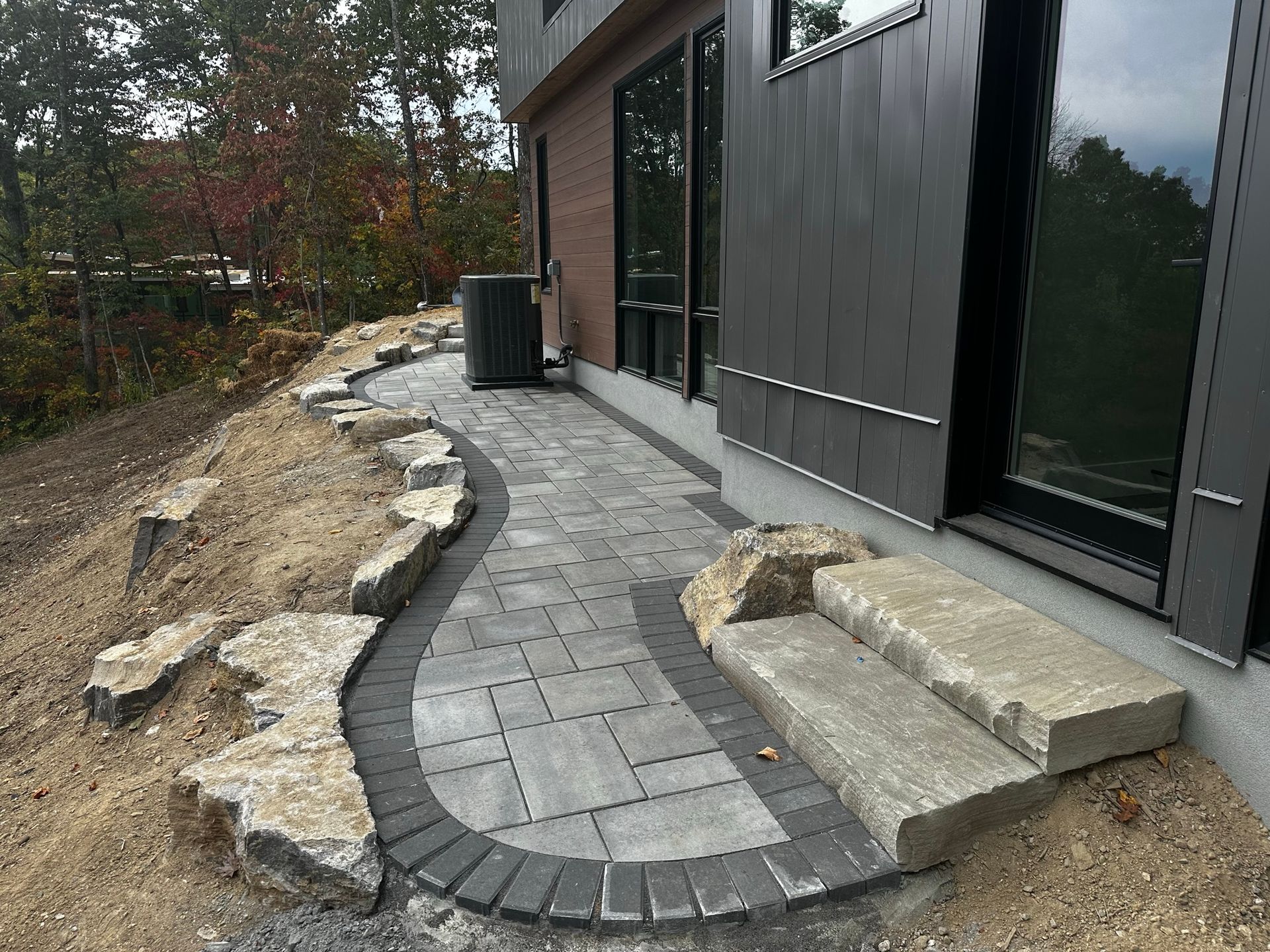 A brick walkway is being built in front of a house.