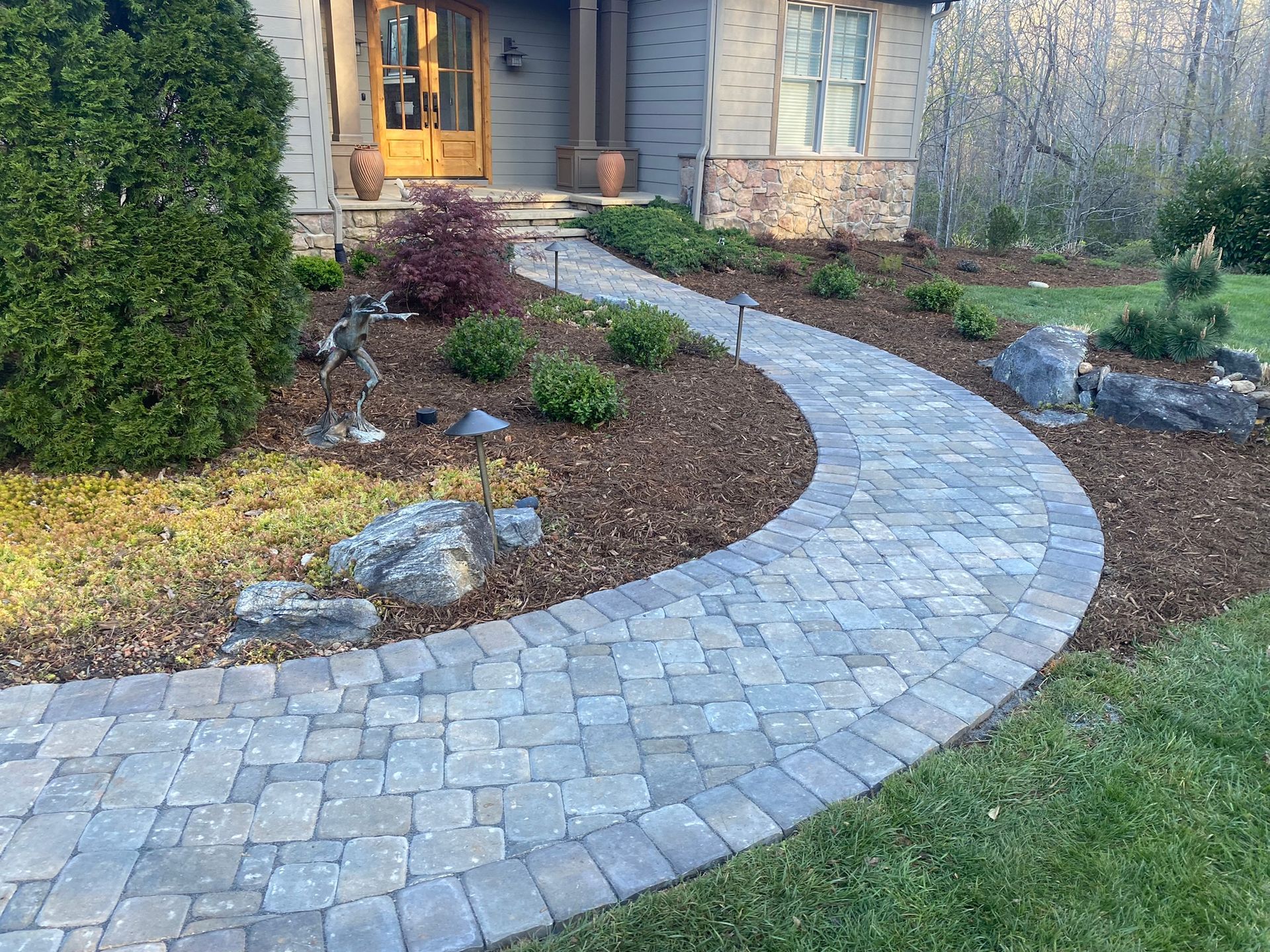 A brick walkway leading to the front door of a house.
