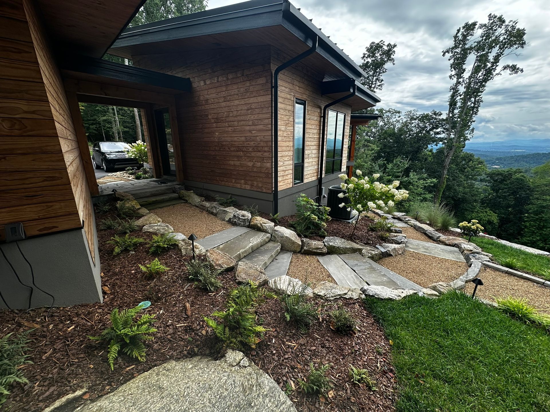A house with stairs leading up to it is sitting on top of a hill.