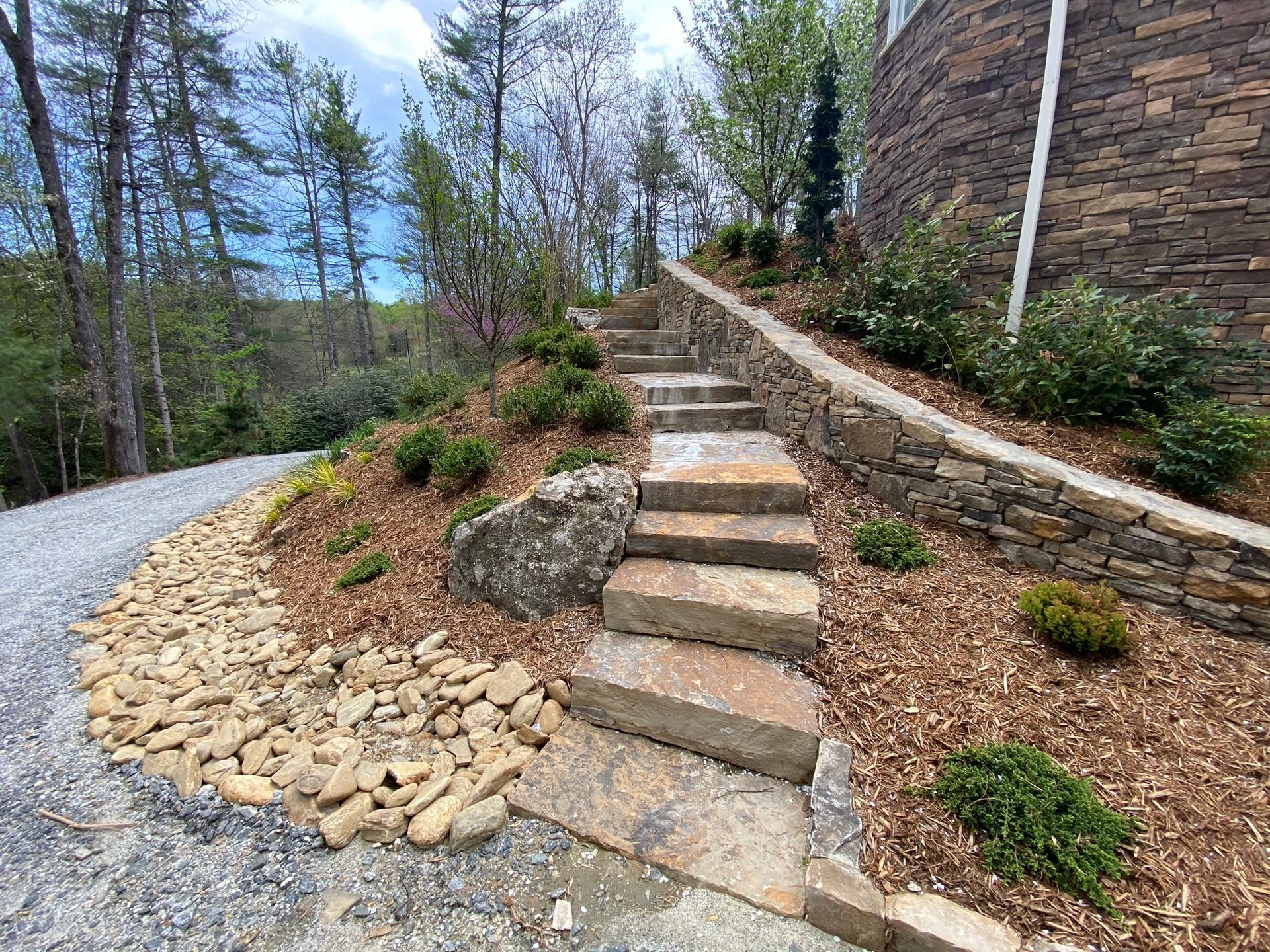 A set of stone stairs leading up to a house in the woods.