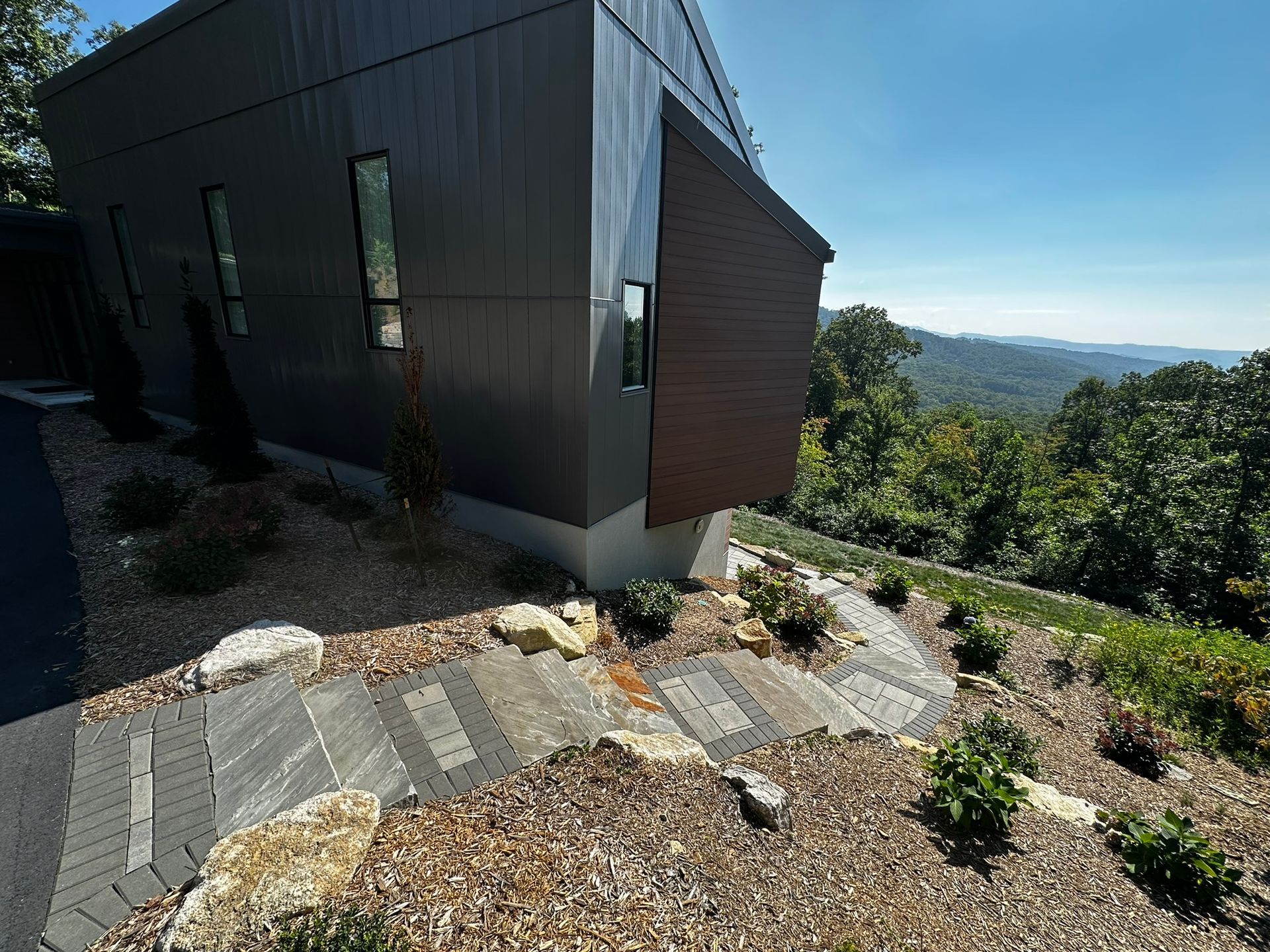 A house on a hill with a view of the mountains.