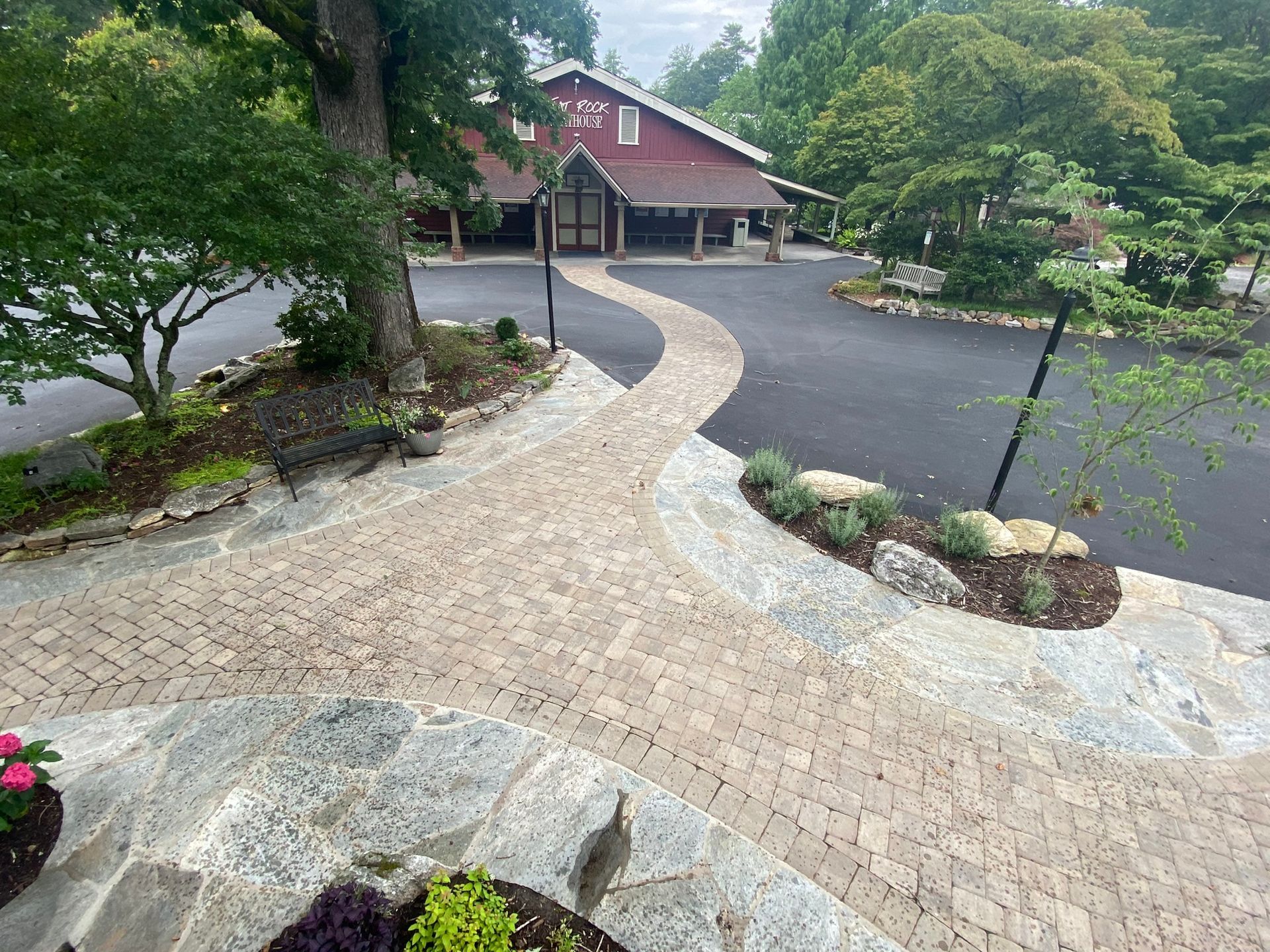 A brick walkway leading to a building with a red roof.