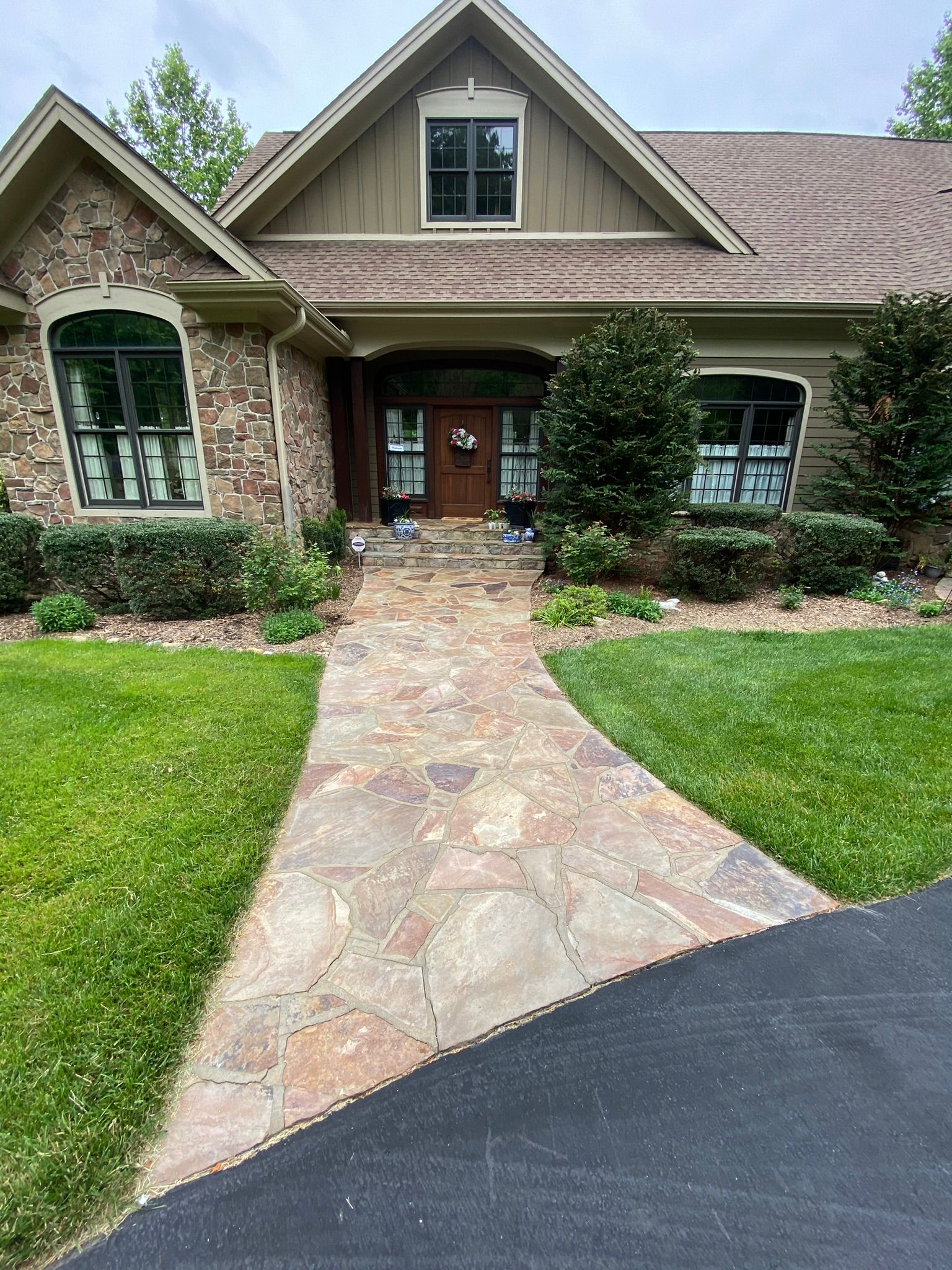 A large house with a stone walkway leading to the front door.