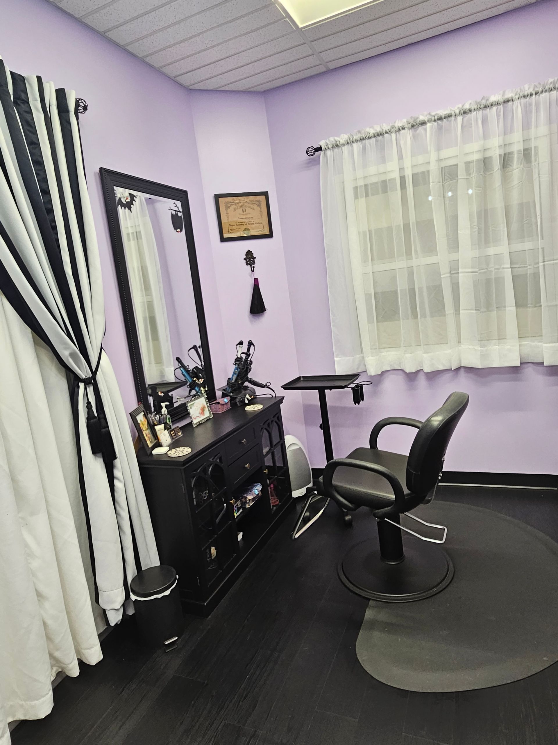 A room with purple walls and a black chair in it.