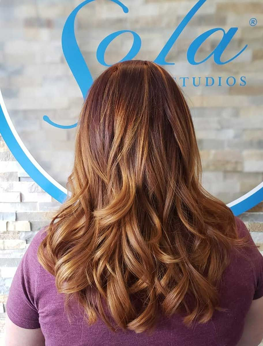 A woman is standing in front of a sign that says Sola Studios.