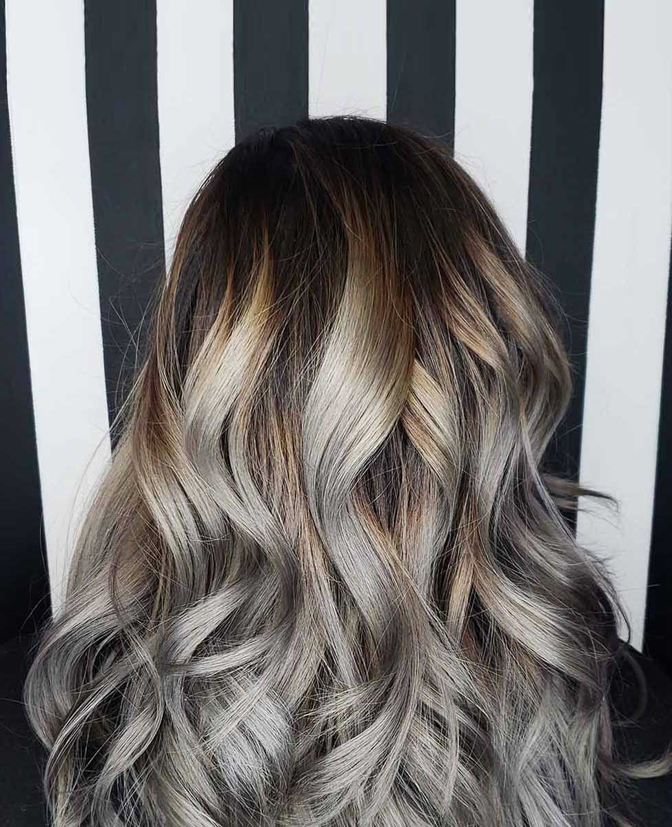 A close-up of a woman's hair in front of a black and white striped background.