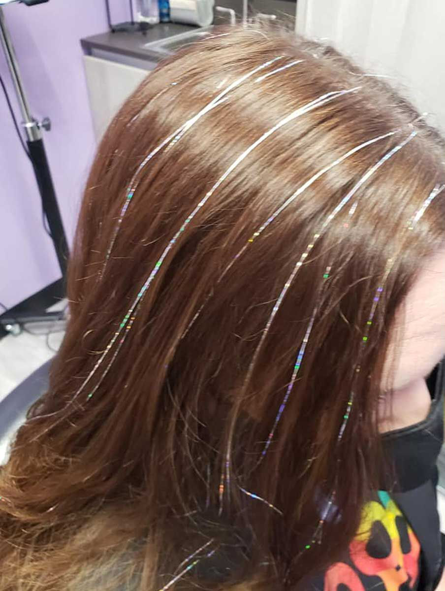 A close-up of a woman with hair tinsel.