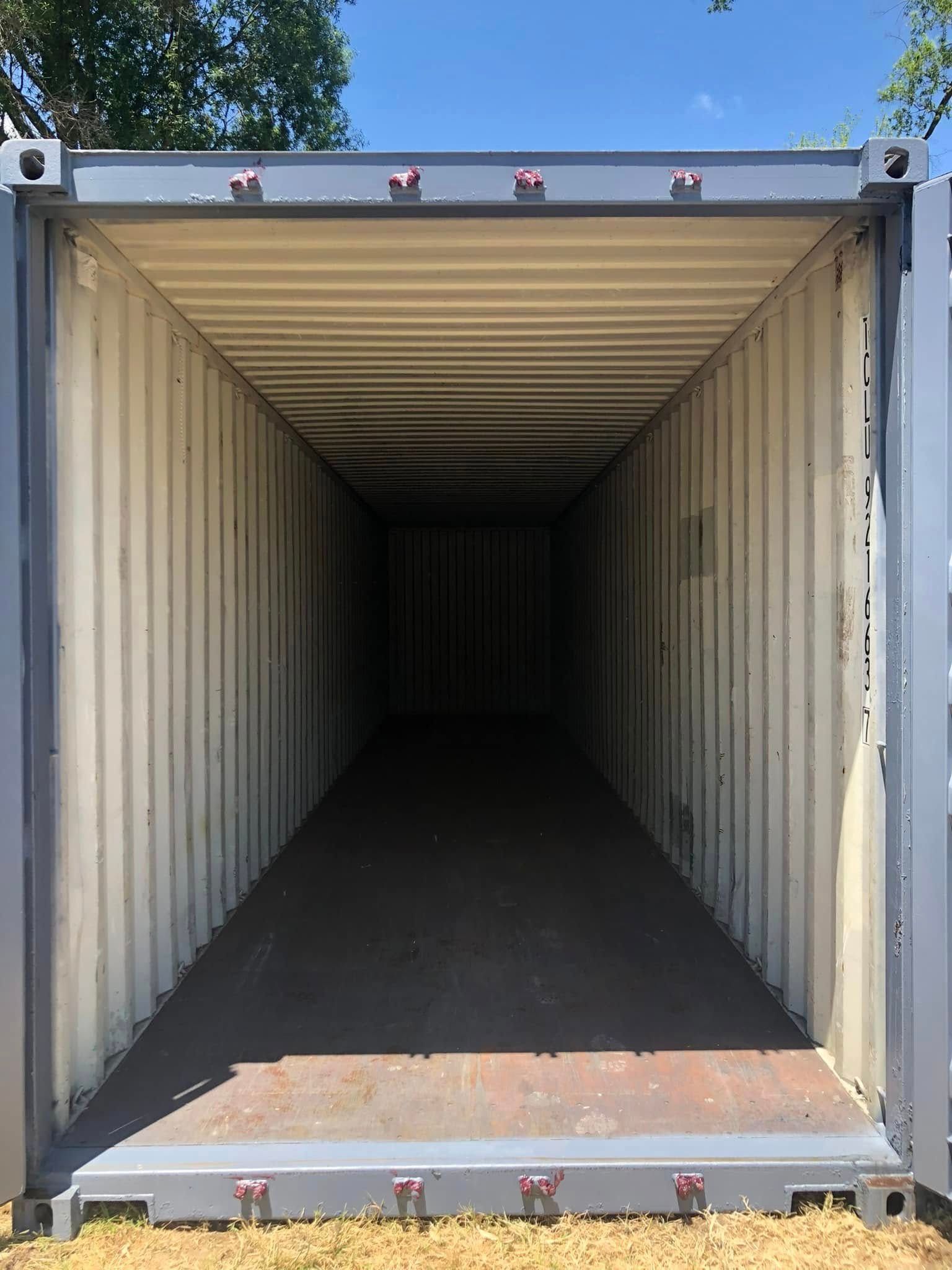 The open, empty interior of a gray steel shipping container viewed from the doorway.