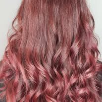 A close up of a woman 's long wavy red hair.