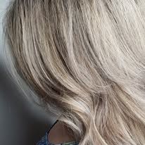 A close up of a woman 's blonde hair in a ponytail.