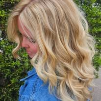 A woman with long blonde hair is wearing a denim jacket.