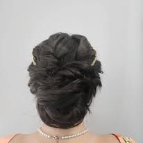The back of a woman wearing a bun and a necklace.