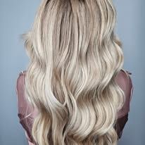 The back of a woman with long blonde hair is shown.