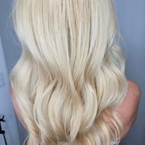 The back of a woman with long blonde hair is shown.