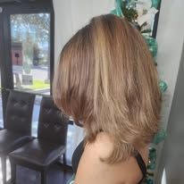 A woman with long blonde hair is sitting in a chair in a room.