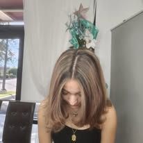 A woman is sitting in a room with a flower in her hair.