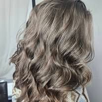 A woman with long wavy hair is wearing a sweater.