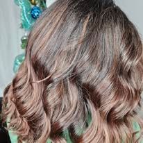 A close up of a woman 's hair with a christmas tree in the background.