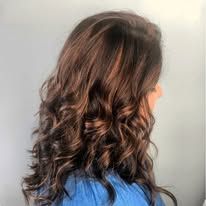 A woman with long brown hair is wearing a blue shirt.