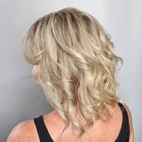 A woman with blonde hair is wearing a black tank top.