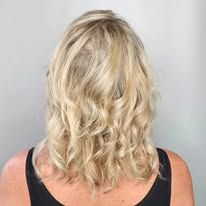 A woman with blonde hair is wearing a black tank top.