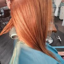 A woman is getting her hair blow dried in a salon.