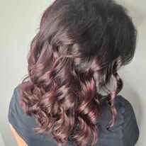 A woman with purple hair is wearing a black shirt.