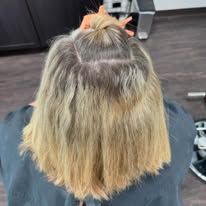 A woman is getting her hair dyed in a salon.