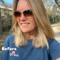 A woman wearing sunglasses and a blue shirt is smiling.