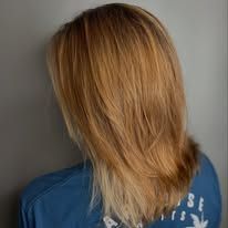 A woman with long blonde hair is wearing a blue shirt.