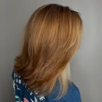 A woman with long blonde hair is wearing a blue shirt.