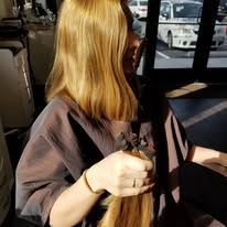 A woman is holding a bunch of hair in her hands.
