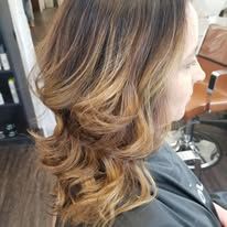 A woman is sitting in a chair with her hair cut in a salon.