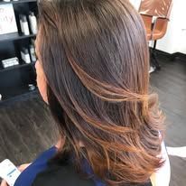 A woman is sitting in a chair with her hair in a salon.