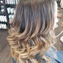 A woman is sitting in a chair with her hair in a salon.