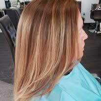 A woman is getting her hair cut in a salon.