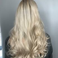 The back of a woman with long blonde hair is shown.