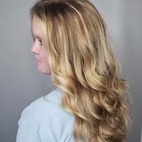 A woman with long blonde hair is wearing a blue shirt.