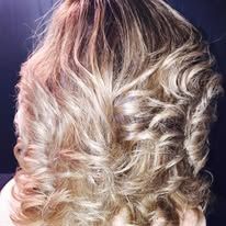 A close up of a woman 's hair with curls.