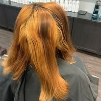 A woman is getting her hair cut at a salon.