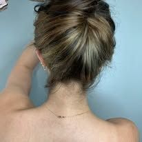The back of a woman with her hair in a bun.