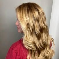 A woman with long blonde hair is wearing a red shirt.