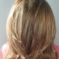The back of a woman 's head with long blonde hair.