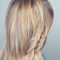 The back of a woman 's head with long blonde hair.