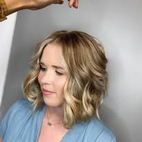 A woman is getting her hair done by a hairdresser.