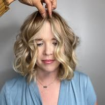 A woman is getting her hair cut by a hairdresser.