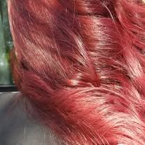 A close up of a woman 's red hair sitting in a car.