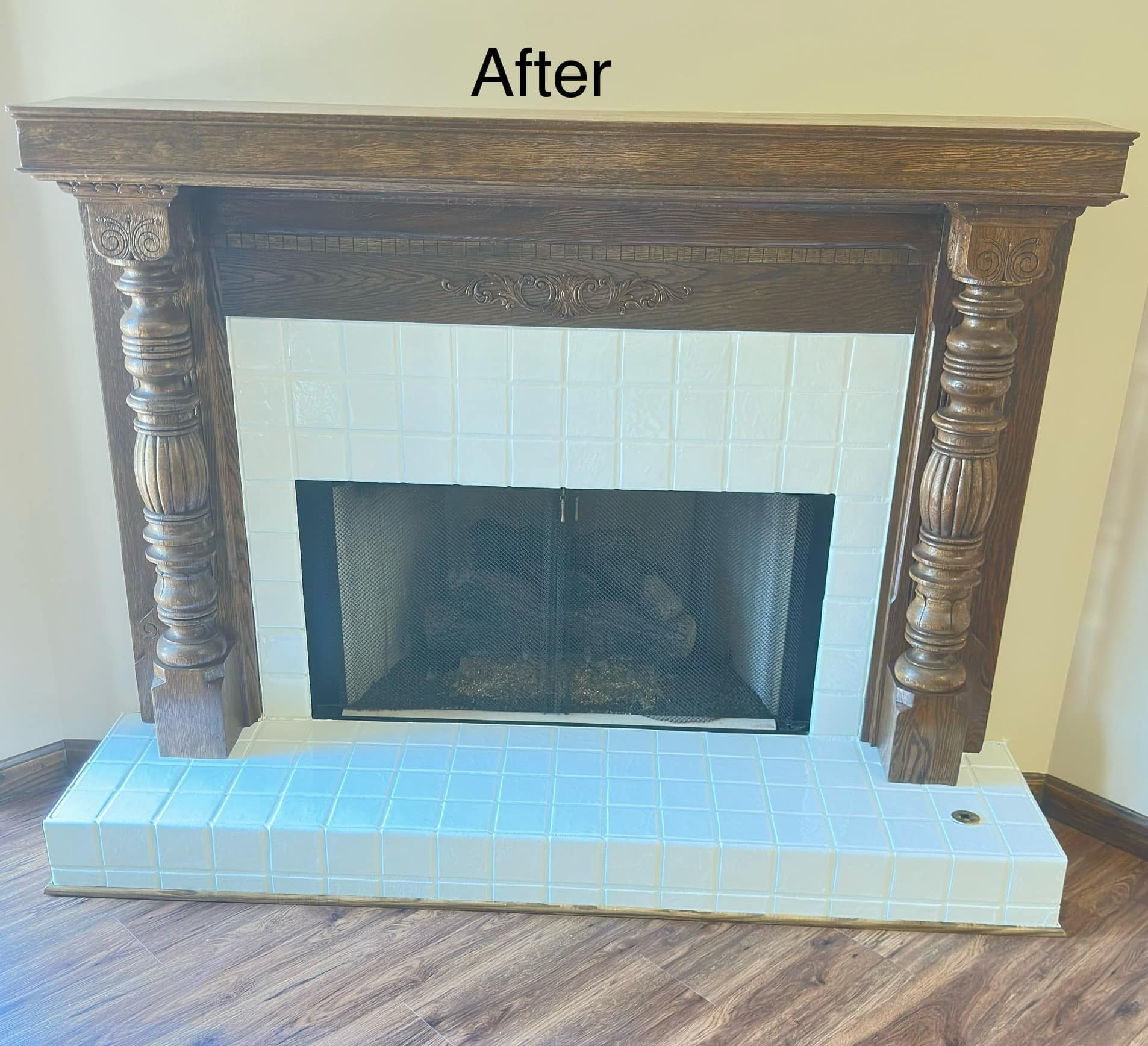 Finished fireplace with dark wooden mantel, white tile, and a black firebox.